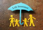 Paper family of four under a Life Insurance paper cutout umbrella