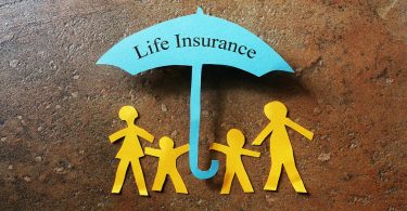 Paper family of four under a Life Insurance paper cutout umbrella