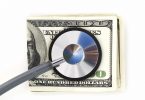Stethoscope with hundred dollar bills on a white background. Financial check up.