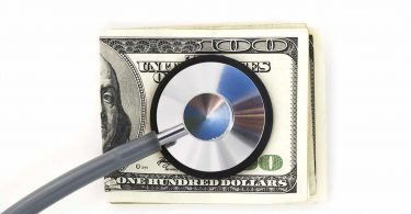 Stethoscope with hundred dollar bills on a white background. Financial check up.
