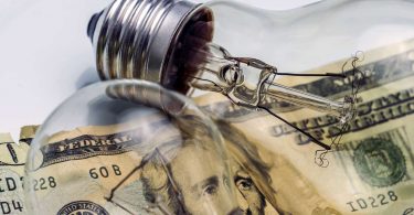 A lightbulb on dollar bill energy saving concept
