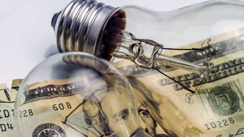A lightbulb on dollar bill energy saving concept