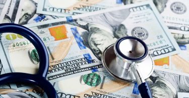 A medical stethoscope on dollars