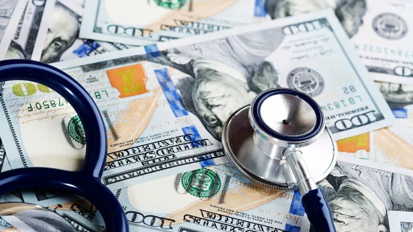 A medical stethoscope on dollars