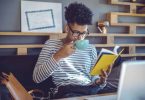 Young man reading a book in office