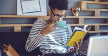 Young man reading a book in office