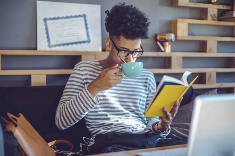 Young man reading a book in office