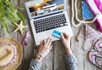 Woman's hands holding credit card in front of laptop