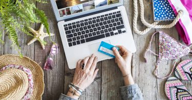 Woman's hands holding credit card in front of laptop