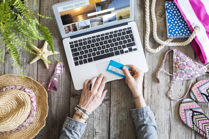 Woman's hands holding credit card in front of laptop