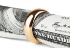 One hundred dollar bill in a gold wedding ring