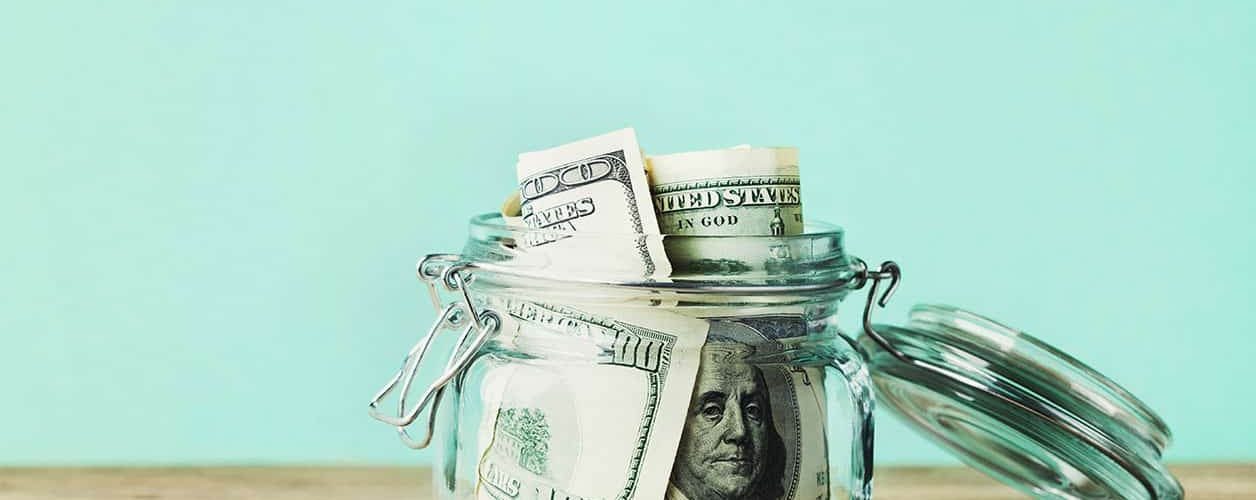 Dollar bills in glass jar. Saving money, economy, finance concept