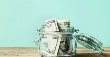 Dollar bills in glass jar. Saving money, economy, finance concept