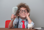 Happy child holding money dollars in hand