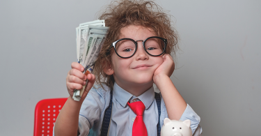 Happy child holding money dollars in hand