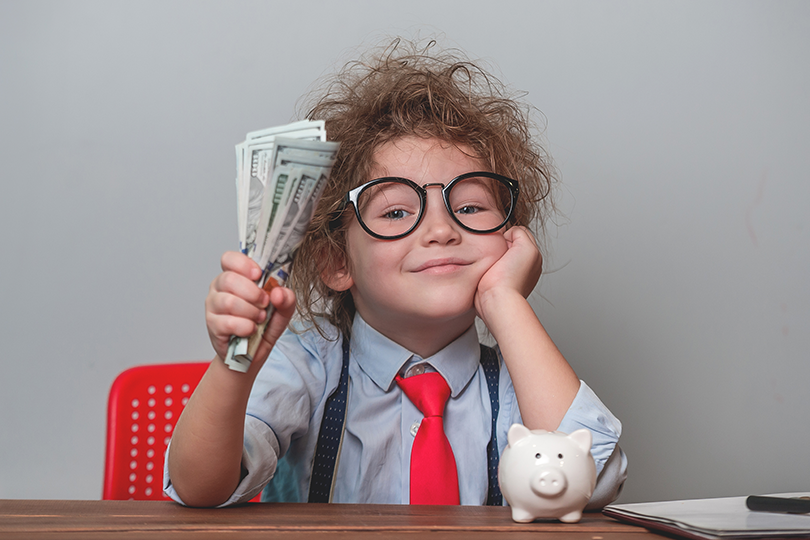 Happy child holding money dollars in hand