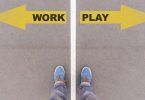 Work vs Play text on yellow arrows on asphalt ground