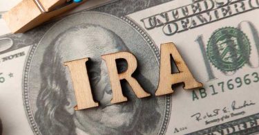 Top view wooden word and banknotes with text IRA